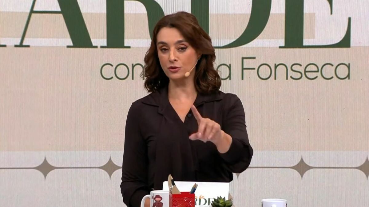 Catia Fonseca, vestindo uma blusa social prata, na bancada do Melhor da Tarde