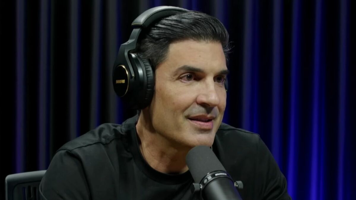 Edu Guedes com fones de ouvido e microfone, em trecho de entrevista ao podcast Papagaio Falante