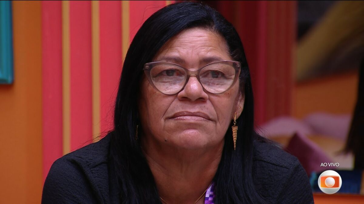 Delma de óculos de grau na sala do BBB 25 olhando para o telão após dá imunidade para Eva