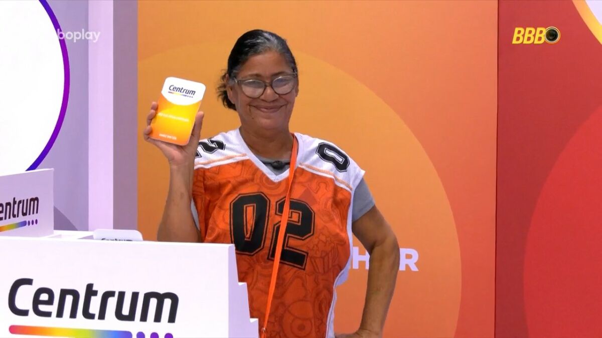 Delma sorrir ao segurar card