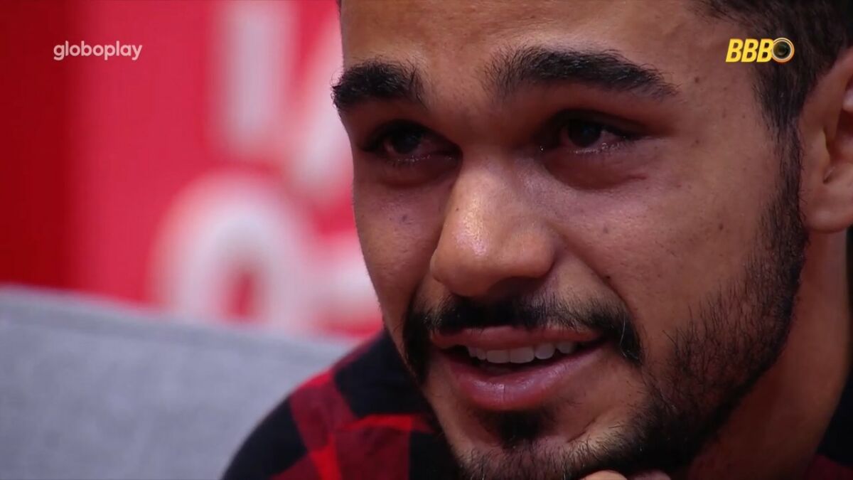João Gabriel com lágrimas nos olhos olhando para a tela do Almoço do Anjo do BBB 25
