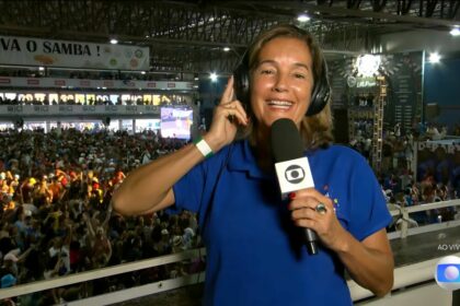 Lilia Teles segura o microfone da TV Globo na quadra da Beija-Flor campeã do carnaval 2025 do Rio de Janeiro