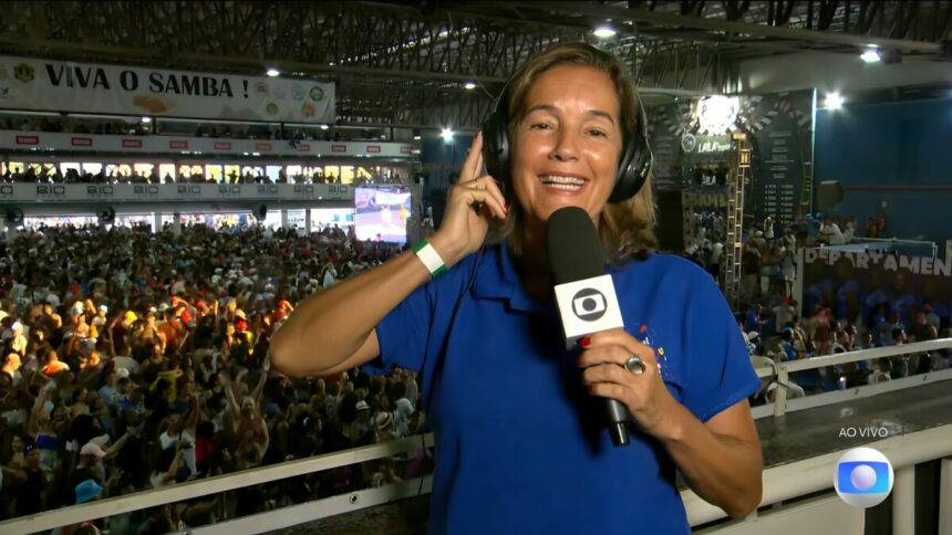 Lilia Teles segura o microfone da TV Globo na quadra da Beija-Flor campeã do carnaval 2025 do Rio de Janeiro