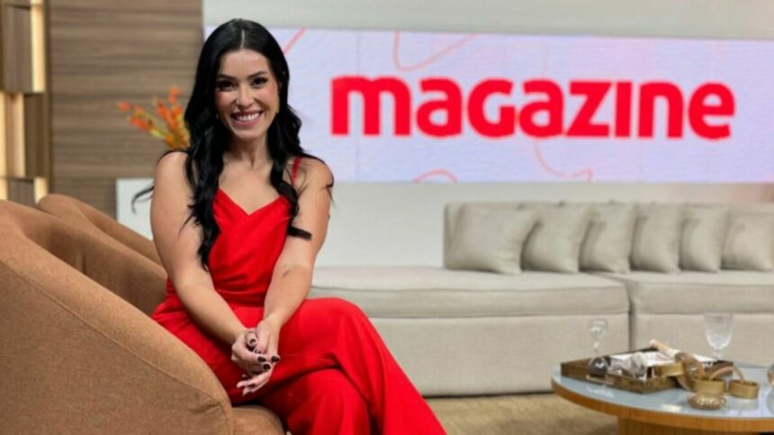 Naiandra Amorim está com uma roupa vermelha sentada no cenário do Magazine