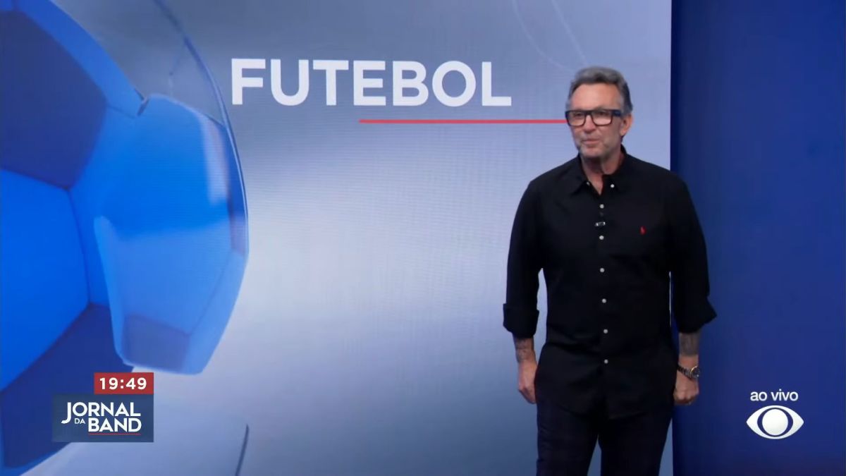 Craque Neto em frente ao telão do Jornal da Band com o logo do Futebol