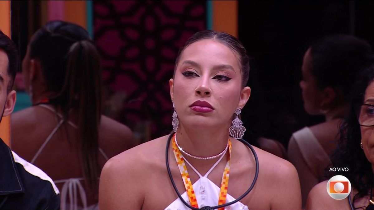 Renata com o colar de líder no pescoço e com olhar sério ao barrar de sua festa Vinicius, no BBB 25