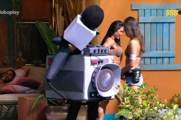 Thamiris vestida com Castigo do Montro que é uma câmera gigante de pelúcia na beira da piscina do BBB 25