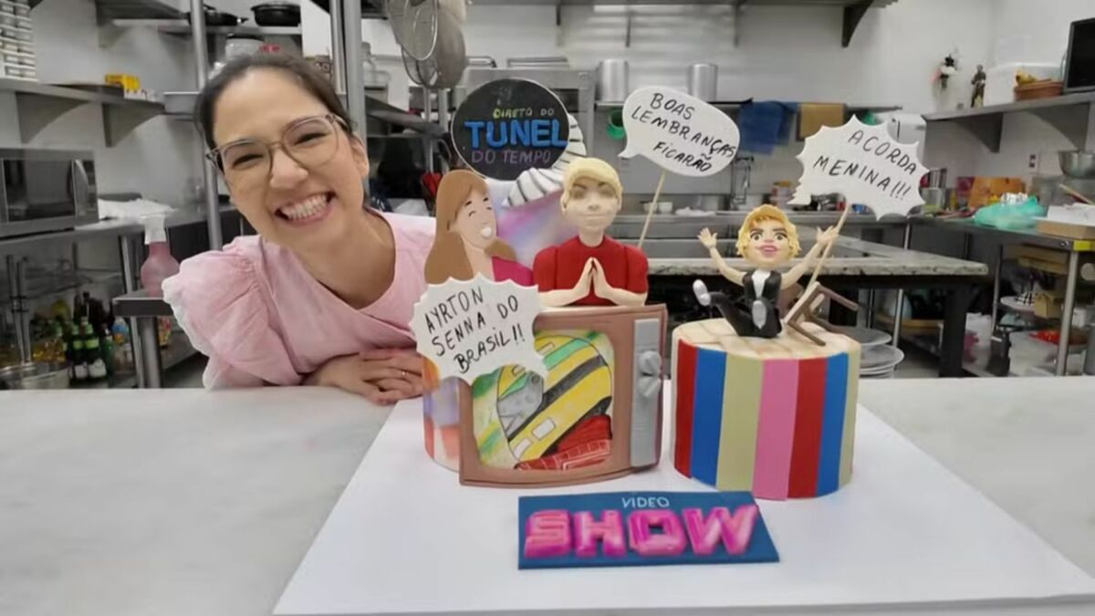 Carol Niwa sorridente ao lado do seu bolo no reality Bolo de Aniversário da TV Globo