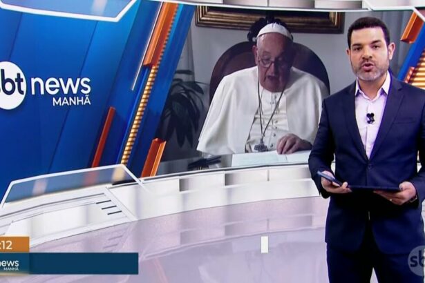 Darlisson Dutra, no estúdio do SBT News, informando a morte de Papa Francisco, que tem sua imagem exposta no telão