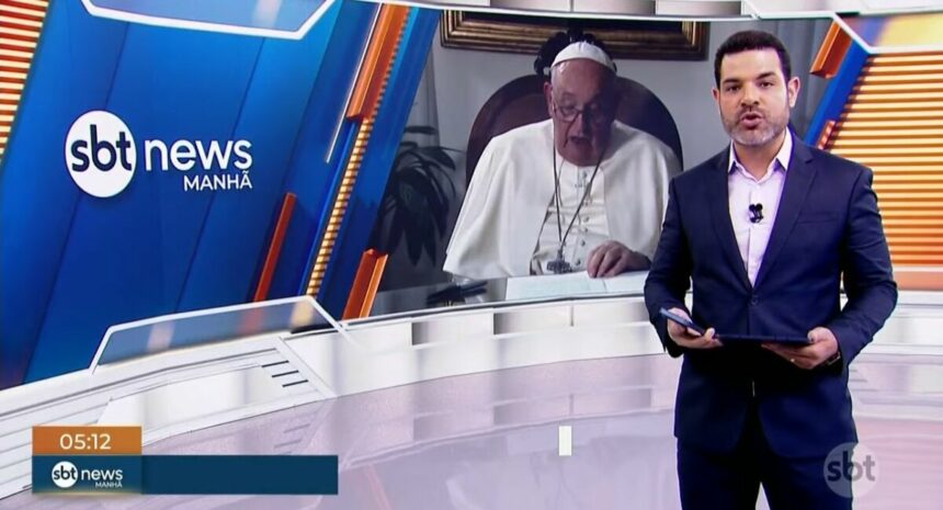 Darlisson Dutra, no estúdio do SBT News, informando a morte de Papa Francisco, que tem sua imagem exposta no telão