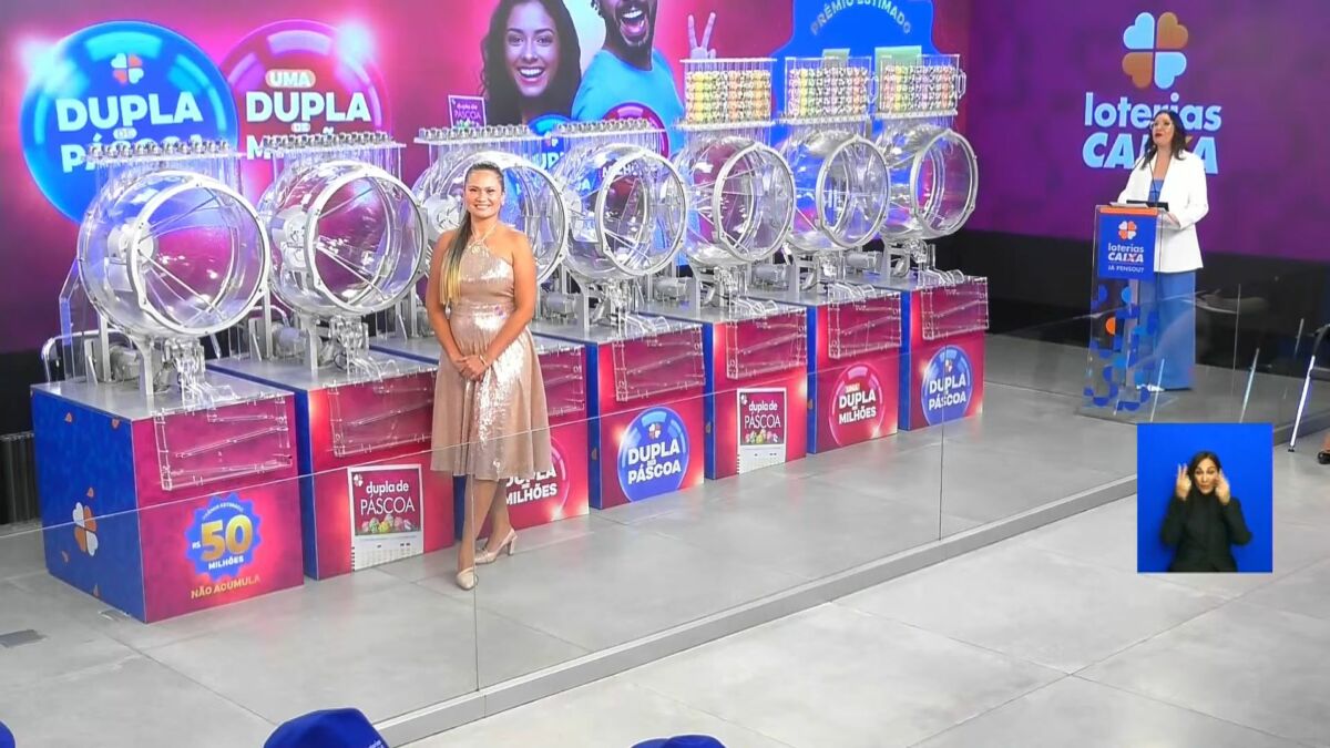 Assistente de palco na frente dos globos com as bolas do sorteio da Dupla de Páscoa 2025