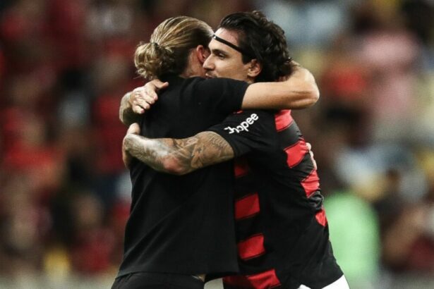 Filipe Luís e Pedro se abraçando em campo com a camisa do Flamengo
