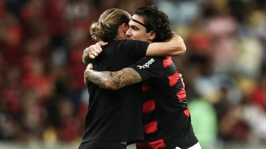 Filipe Luís e Pedro se abraçando em campo com a camisa do Flamengo