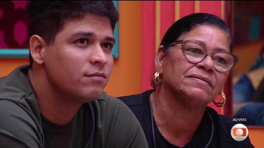 Guilherme sentado no sofá do BBB 25 ao lado de Delma com quem enfrenta o Paredão junto com Renata