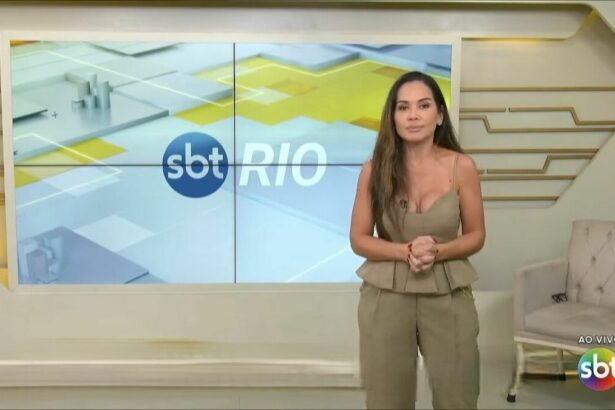 Isabele Benito com semblante sério em frente ao logo do SBT Rio