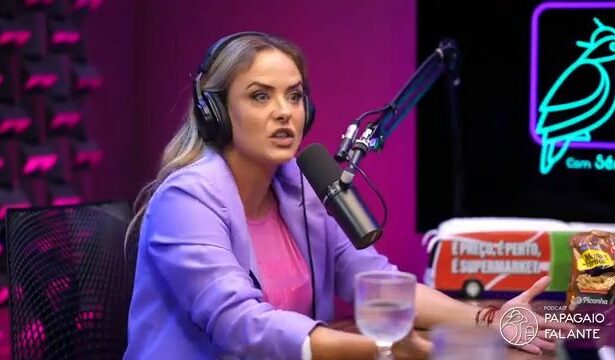 Juliana Silveira de terno lilás e blusa rosa em frente a um microfone de podcast onde revelou denúncia de assédio em novela da RECORD