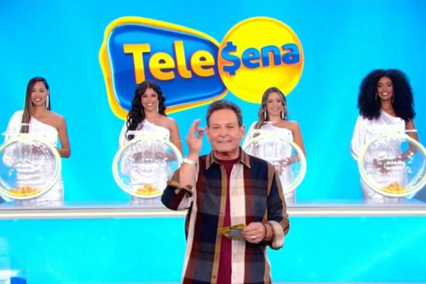 Luis Ricardo levanta o braço enquanto apresenta o sorteio da Tele Sena Semanal 48, o estúdio está azul