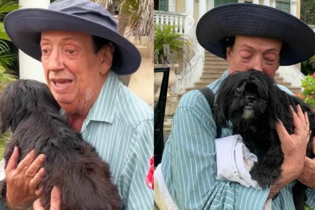 Marcos Oliveira, com a cachorrinha no colo, na chegada ao Retiro dos Artistas