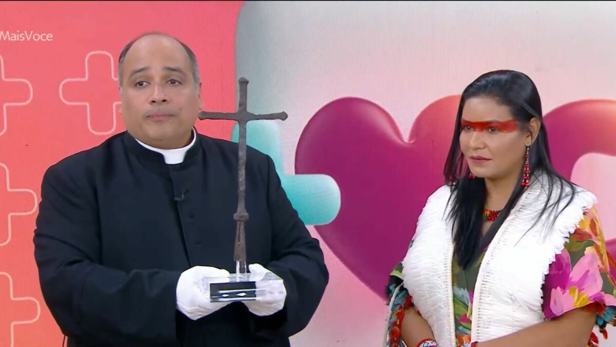 Padre Omar segurando uma cruz no estúdio do Mais Você