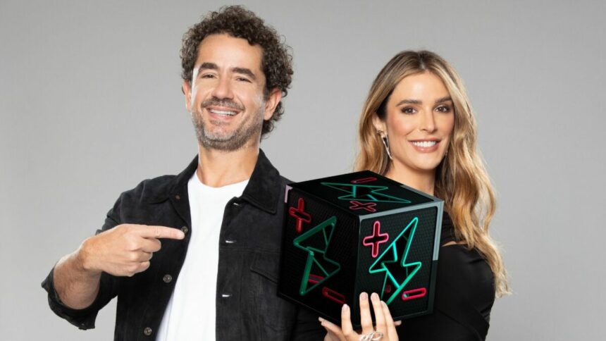 Rafa Brites e Felipe Andreoli, com o dado do Power Couple em mãos, em foto posada