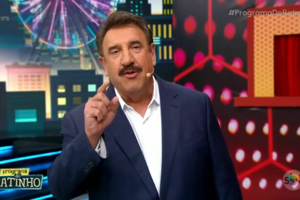 Ratinho de terno e camisa branca levanta o dedo enquanto apresenta o Programa do Ratinho no SBT