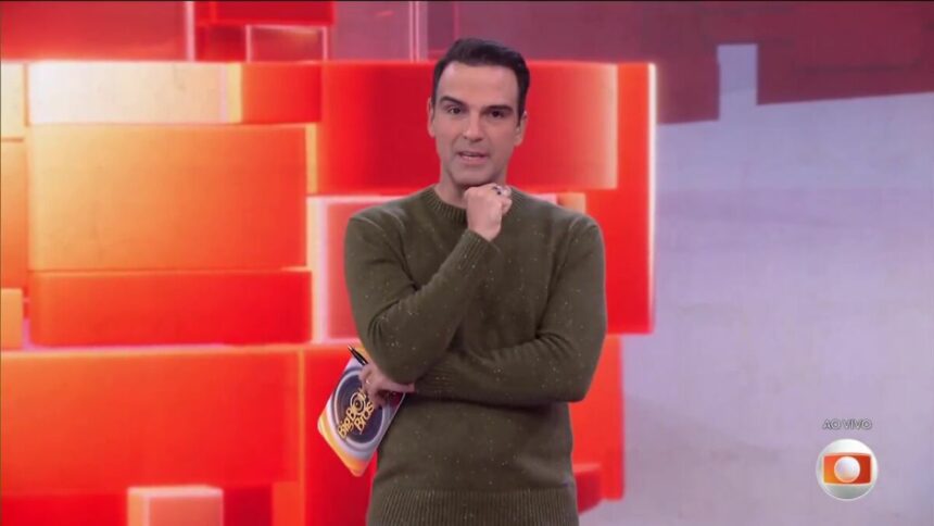 Tadeu Schmidt veste verde e está no centro do cenário do BBB 25, com semblante sério, para falar sobre a Prova do Líder
