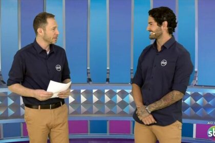 Tiago Leifert ao lado de Alexandre Pato sorridentes, e em pé no cenário do Pré-Jogo da Champions League no SBT