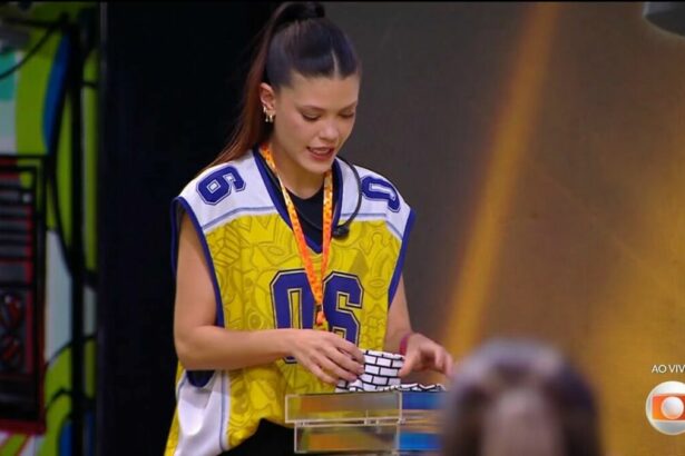 Vitória Strada distribuindo as pulseiras do Na Mira do Líder no BBB 25