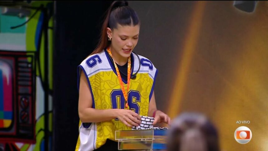 Vitória Strada distribuindo as pulseiras do Na Mira do Líder no BBB 25
