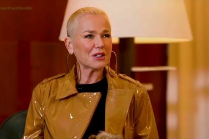 Xuxa de jaqueta marrom brilhosa, olhando para Carolina Ferraz na entrevista à RECORD