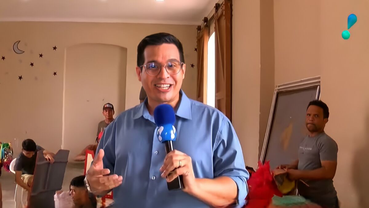 Bruno Araújo segura o microfone da RedeTV! e sorrir