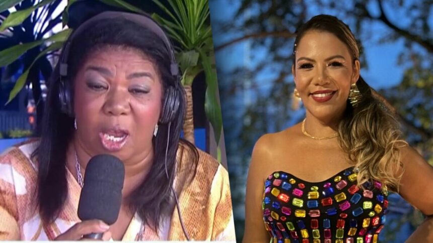 Elisangela com o microfone e fone de ouvido na porta da RECORD Bahia. Ela está com a boca aberta concedendo entrevista. Mani Rego veste um cropped colorido de pedras brilhantes. Ela está no entardecer e sorrindo.