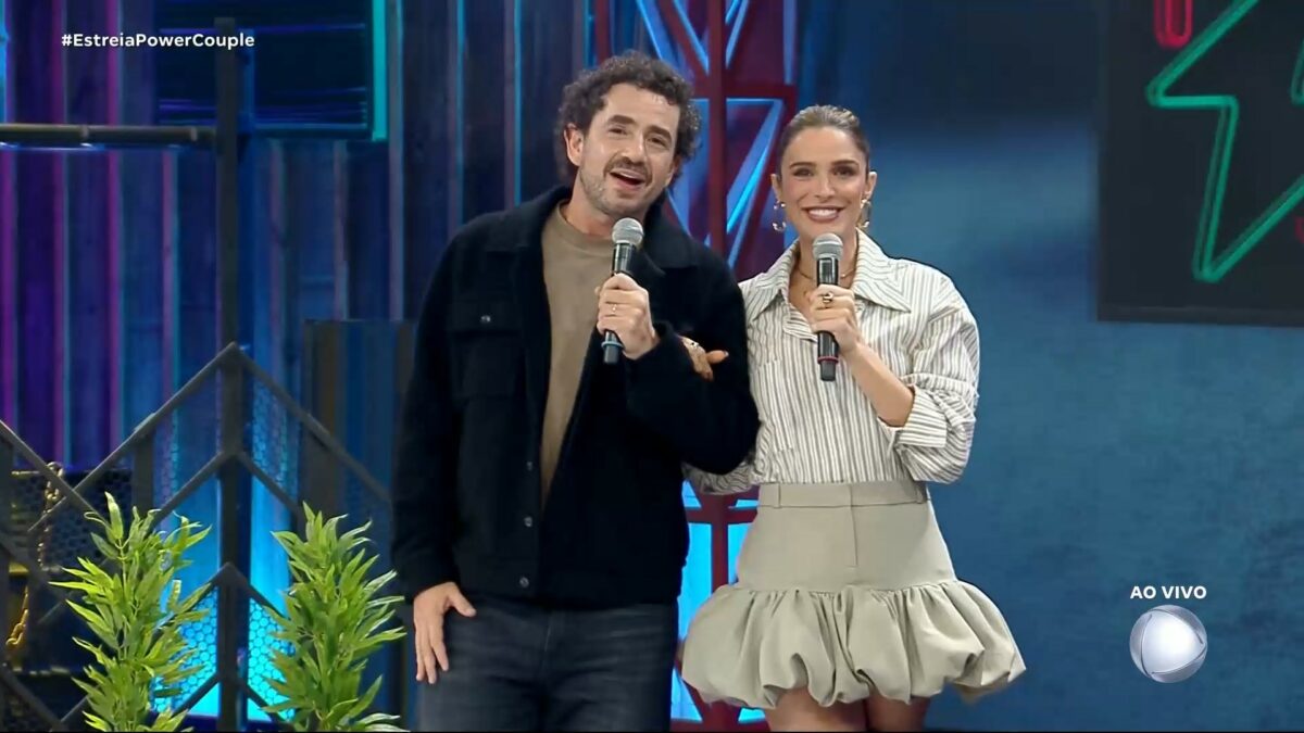 Felipe Andreoli ao lado de Rafa Brites. Os dois estão sorrindo, em pé, no palco do Power Couple Brasil 7