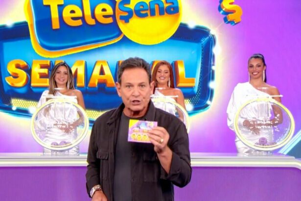 Luiz Ricardo segura bilhete da Tele Sena Semanal de número 46, com o cenário todo lilás