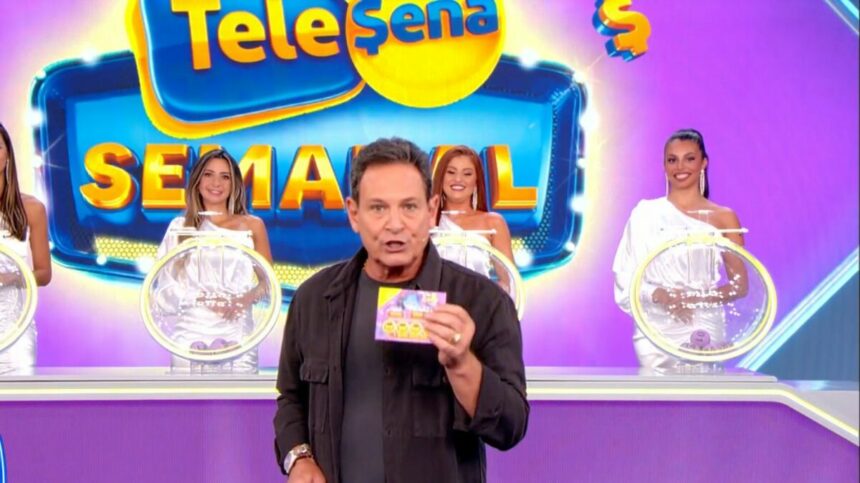 Luiz Ricardo segura bilhete da Tele Sena Semanal de número 46, com o cenário todo lilás