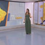 Patrícia Rocha em frente ao telão que carrega o mapa do Brasil, em amarelo, na Previsão do Tempo