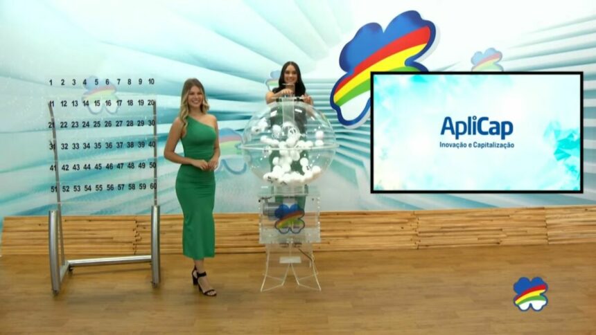 Assistentes de palco vestem verde ao lado do globo com as bolas do sorteio do Pernambuco dá Sorte