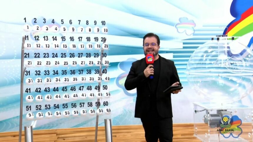 Apresentador do Pernambuco dá Sorte em frente ao painel com as bolas do sorteio
