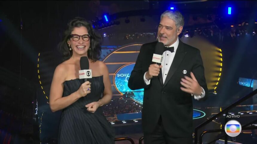 Renata Vasconcellos e William Bonner apresentando o Jornal Nacional na arquibancada do Show 60 anos da TV Globo