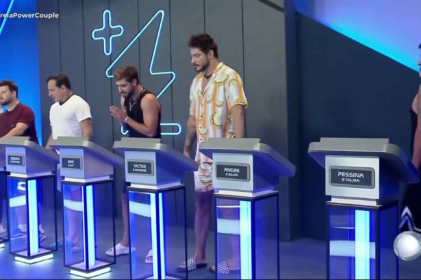 Homens na sala de apostas do Power Couple Brasil 7. Eles estão posicionados atrás de púlpitos com seus respectivos nomes