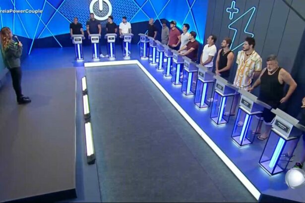 Homens posicionados em seus púlpitos na sala de apostas da 1ª Prova das Mulheres do Power Couple Brasil 7. Rafa Brites está no palco apresentando
