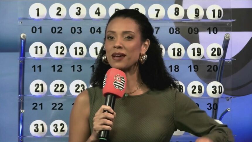 Apresentadora do São Paulo dá Sorte em frente ao painel com as bolas do sorteio do dia 27 de abril