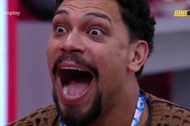 Vinicius com a boca aberta e olhos arregalados ao ver mensagem de fã no almoço do anjo do BBB 25