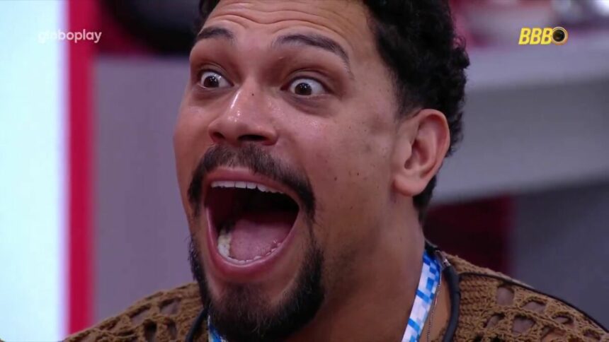 Vinicius com a boca aberta e olhos arregalados ao ver mensagem de fã no almoço do anjo do BBB 25