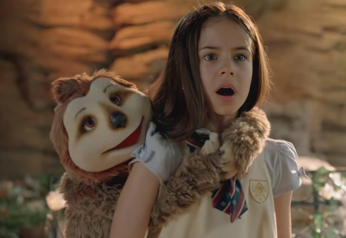 Protagonista de A Caverna Encantada ao lado do personagem de pelúcia em uma caverna. Eles estão assustados