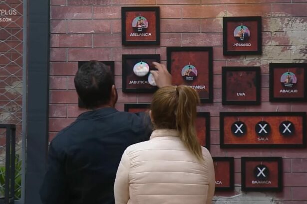 Adriana e Dhomini em frente ao quadro da divisão de quartos no Power Couple Brasil 7