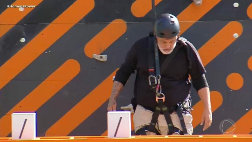 André pendurado na escalada, em trecho da Prova dos Homens no Power Couple