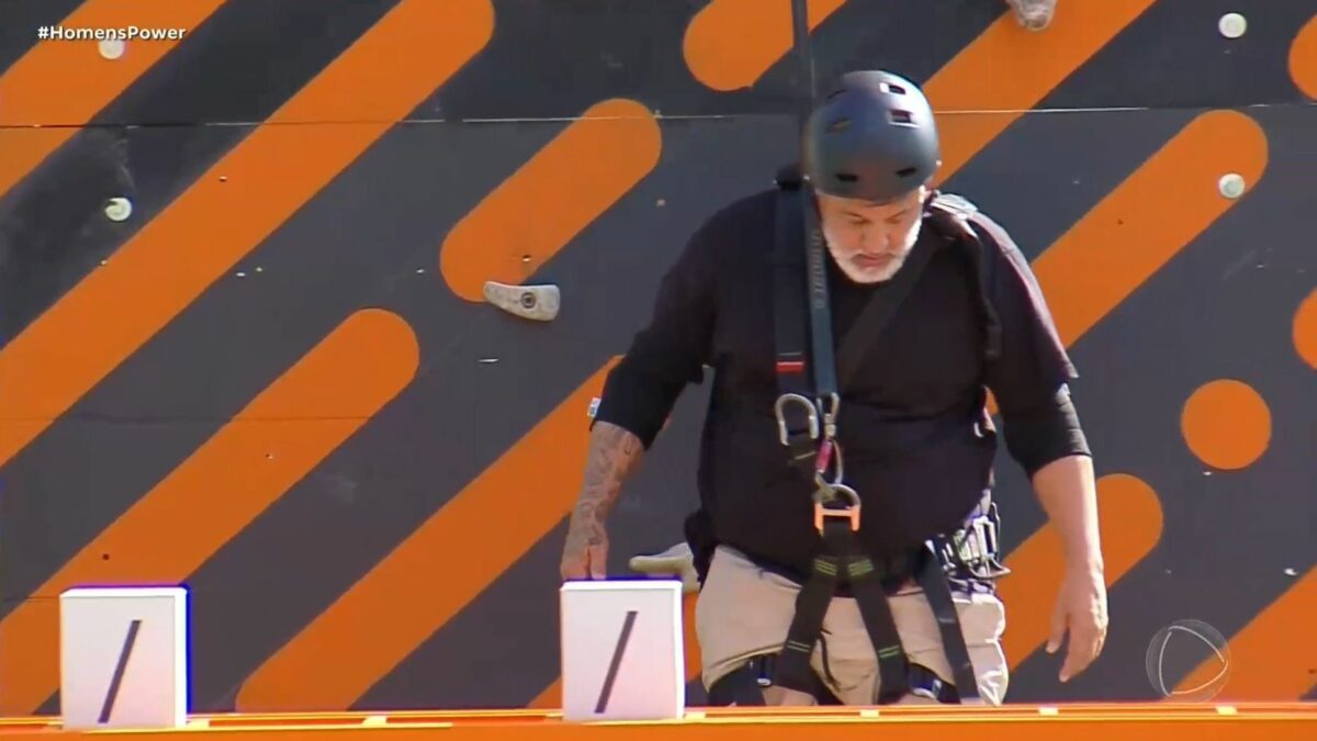 André pendurado na escalada, em trecho da Prova dos Homens no Power Couple