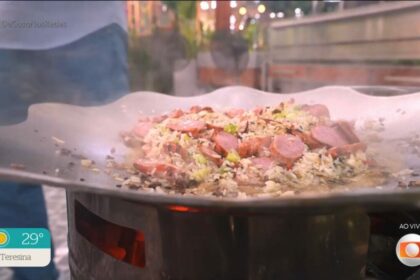 Arroz com linguiça e mandioquinha na brasa na tigela de um fogão a lenha do É de Casa