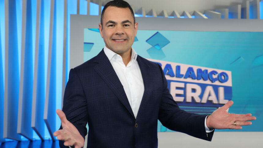 Tino Junior com os braços abertos e feliz no cenário do Balanço Geral RJ